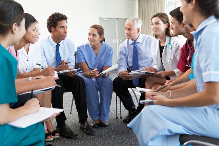 Healthcare workers conversing in a seated circle