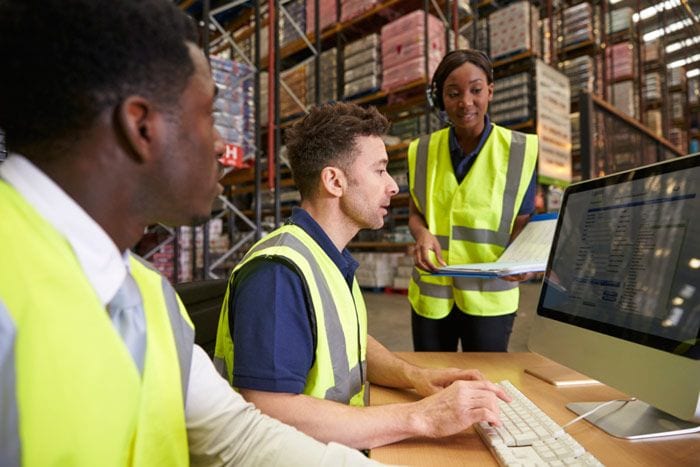 Warehouse workers consulting information at a computer